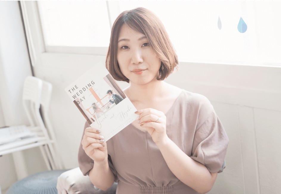 結婚式のプロフィールブックを手に持つはづきさん