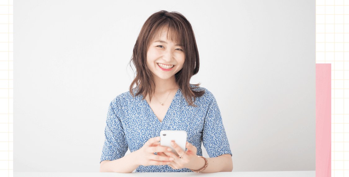 スマートフォンを持つ青い花柄の服の女性（アクセサリー販売の様子）