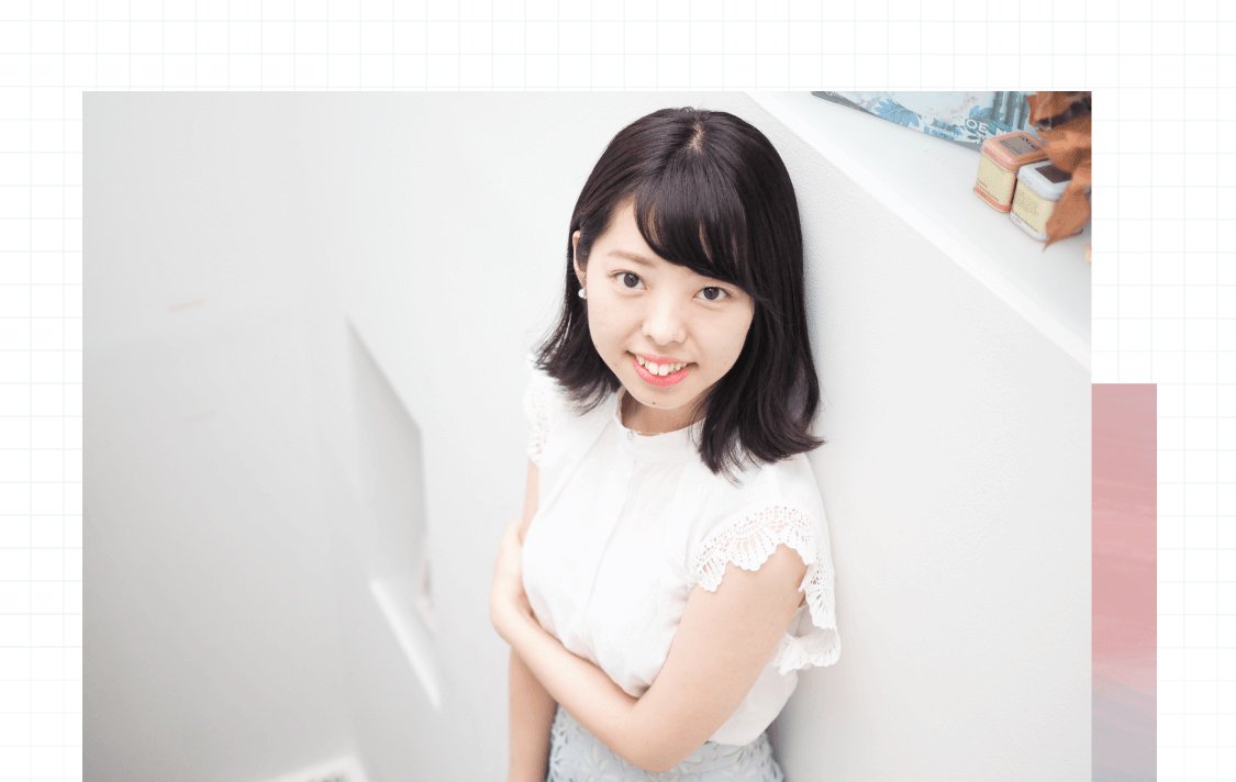 壁にもたれて微笑む伊藤さんのポートレート