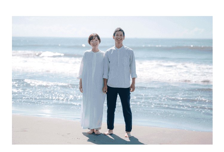 浜辺に並んで立つ知佳さんと夫
