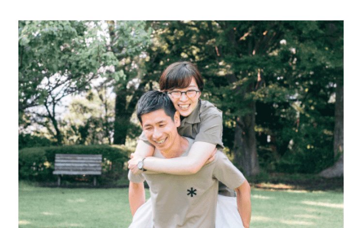 公園でおんぶし合う知佳さんと夫（笑顔）