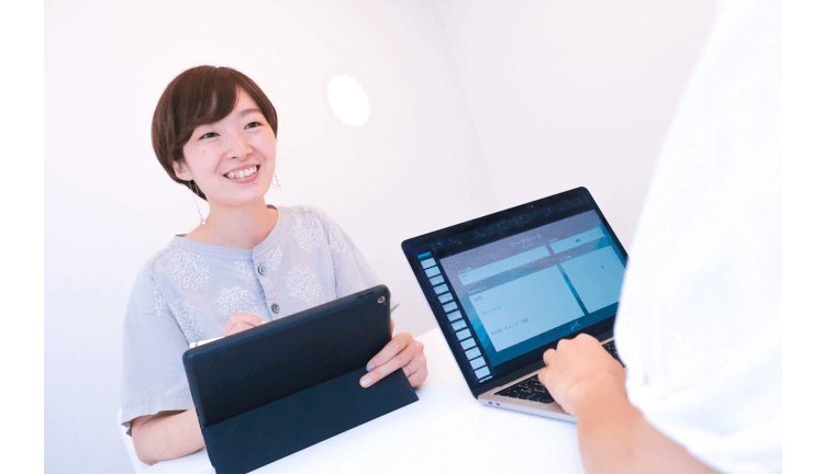 タブレットを持つ知佳さんとノートパソコンを操作するコーチ