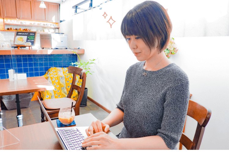 カフェでノートPCを操作する紗季さんの写真