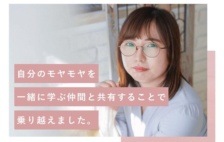 レンガ壁の室内でこちらを見るにゃこさん。「自分のモヤモヤを一緒に学ぶ仲間と共有することで乗り越えました。」