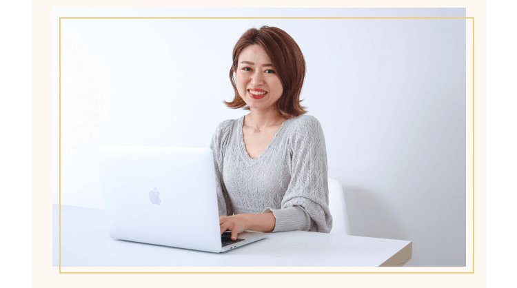 ノートPCを操作しながら微笑む女性
