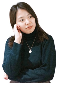 頬に手を当てて振り返るポーズのかんなさん（黒のタートルネック、ネックレス）