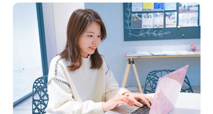 ノートパソコンで作業するかんなさん（白ニット、カフェスペース）