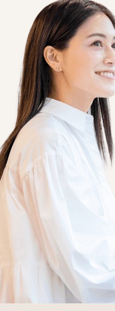 白いブラウスの石井さんが横向きでノートPCに向かうバストショット