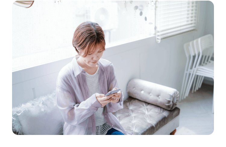 リビングのソファでスマートフォンを操作するみえさん