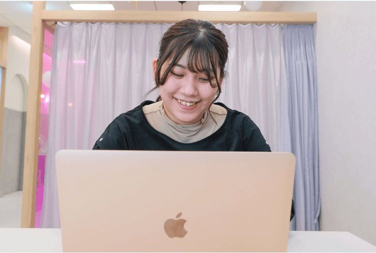 SHE Umedaの教室でノートパソコンに向かって微笑む竹田凜さん