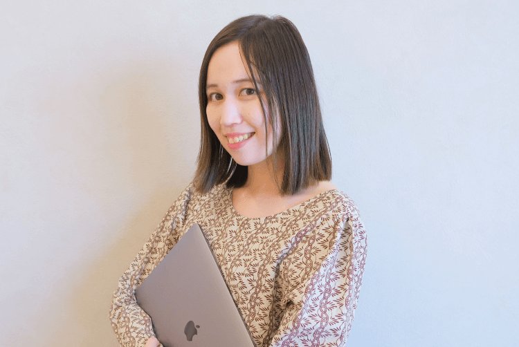 ノートPCを抱えて微笑むみづきさん