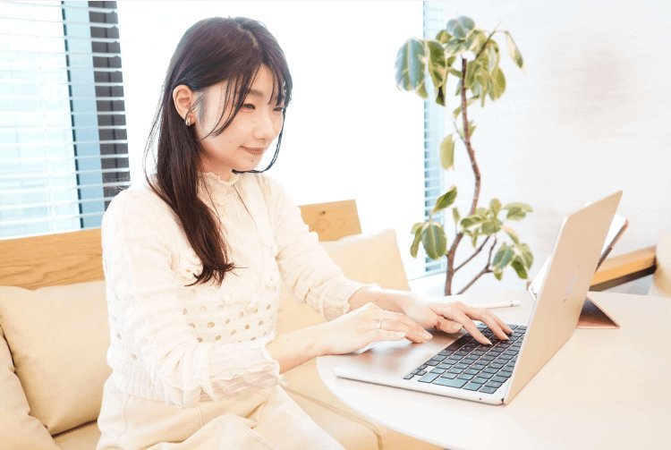 窓際のソファでノートパソコンを操作しながら微笑むちーずさん