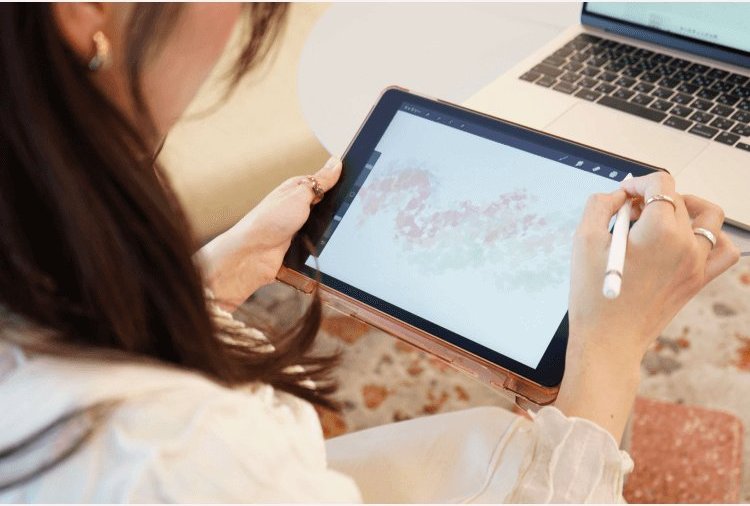 タブレットに水彩風のイラストをペンで描くちーずさんの手元