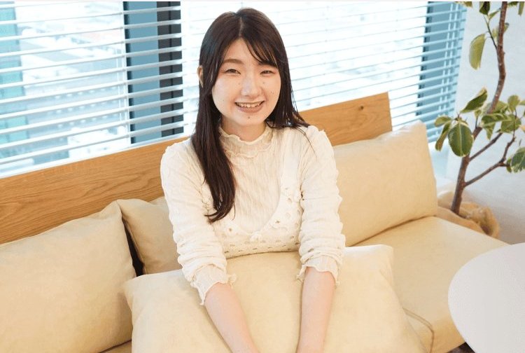 窓際のソファに座り微笑むちーずさんのポートレート