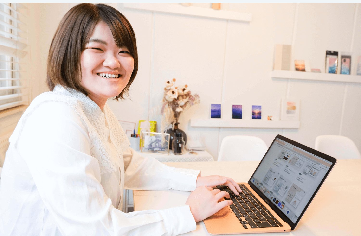 木製テーブルでノートパソコンに向かって微笑むりょうこさん