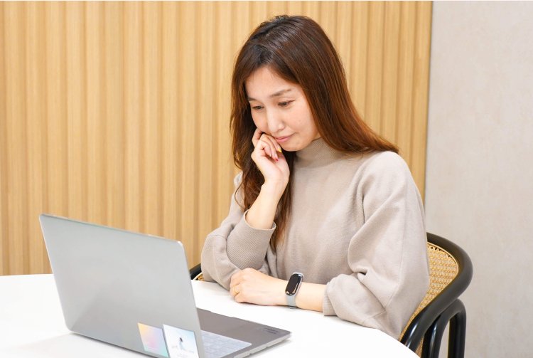 ノートPCの画面を見ながら考え込む表情ののんさん