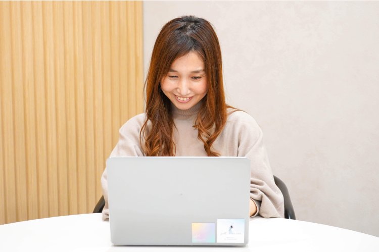 笑顔でノートPCに向かうのんさん