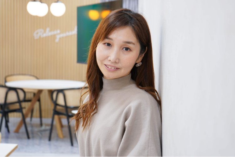 カフェ風の室内で微笑むのんさんのポートレート