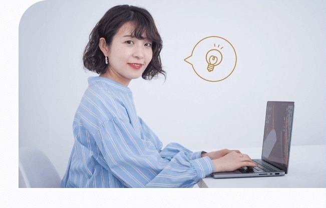 電球アイコンの吹き出しとともにノートパソコンに向かう萌さん