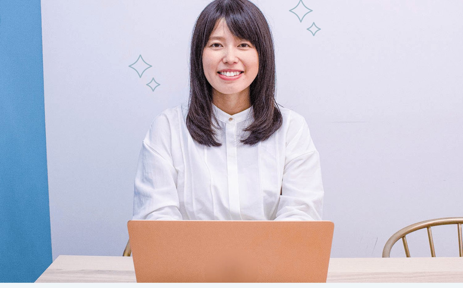 ノートパソコンの前で微笑む女性