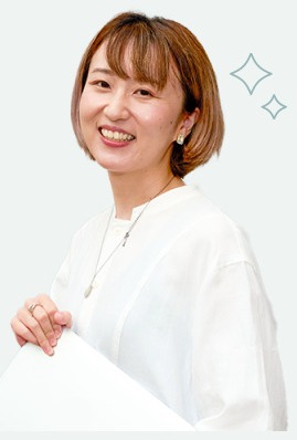 After：微笑んで書類を持つ白トップスのろこさん。キラキラの装飾入り