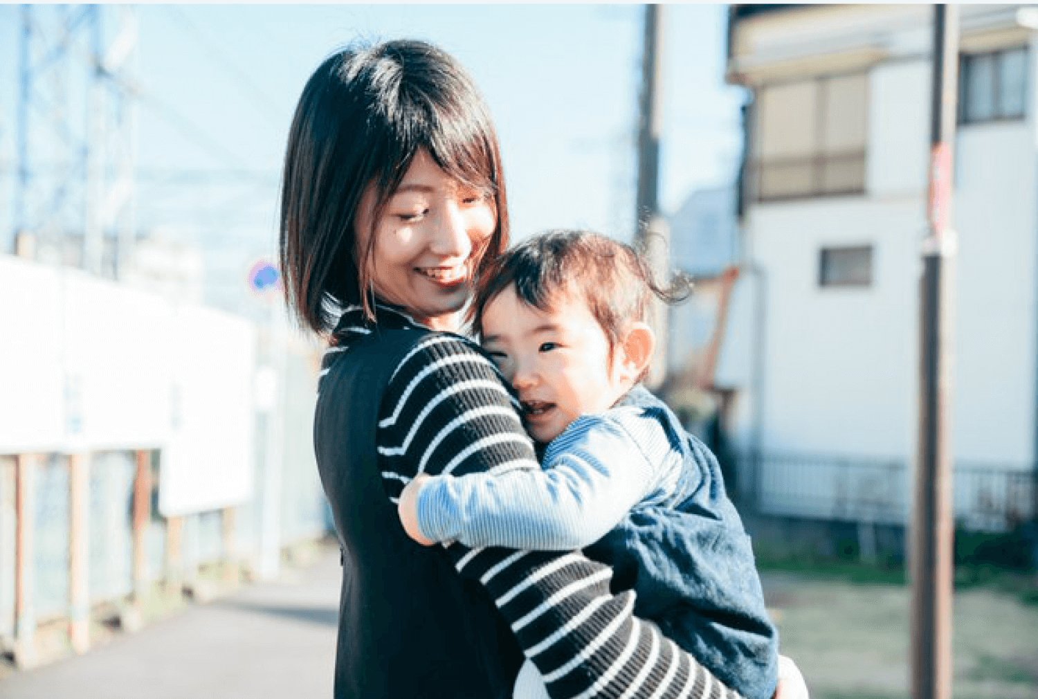 屋外できゃんまりさんが子どもと抱き合って微笑む様子