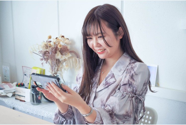 スマートフォンを見て微笑むぴちゃんさん