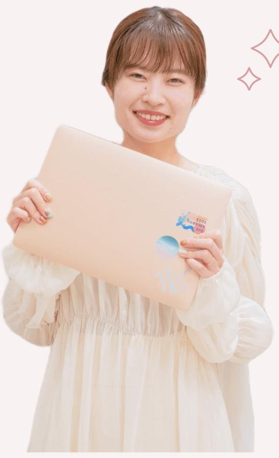ノートPCを抱えて微笑む白ワンピースの女性（After）