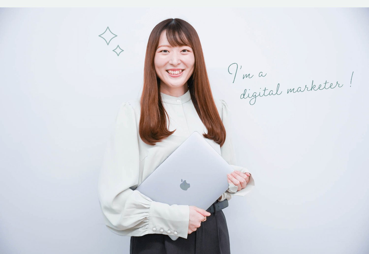 白い壁を背に、ノートPCを抱えて微笑む女性。キラキラの装飾と「I'm a digital marketer!」の手書き風キャプション入り