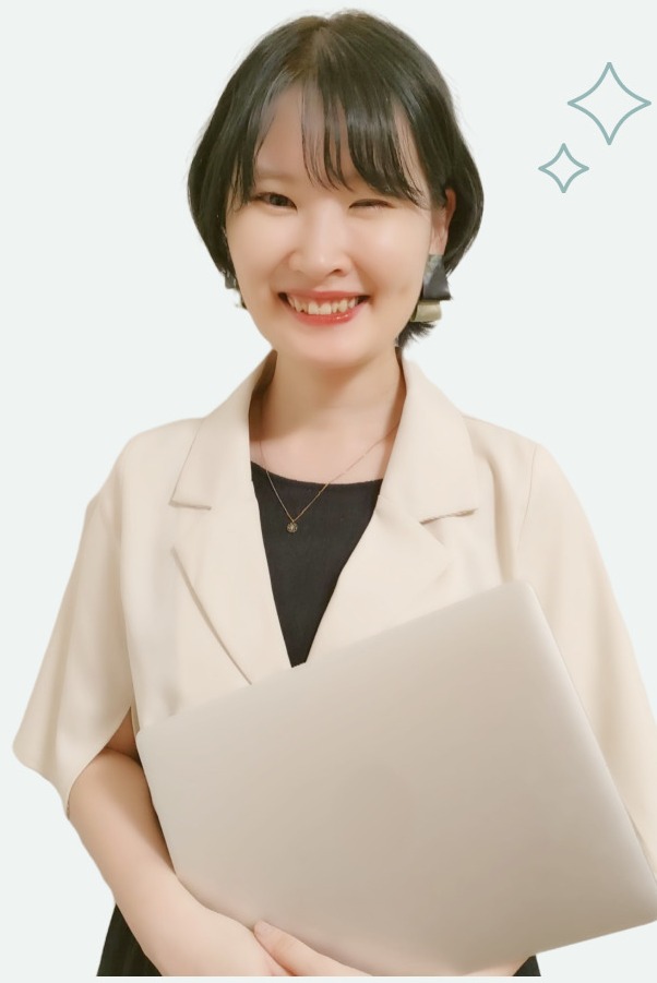 微笑んでノートPCを抱える、キラキラマーク付きのアイボリージャケットの人物（After）