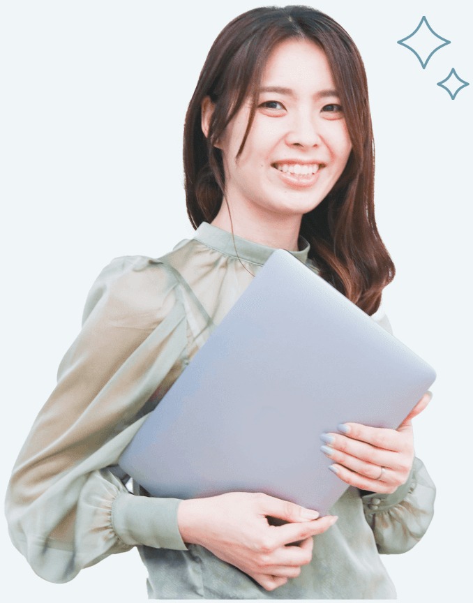 セージグリーンのブラウスでノートPCを抱えて微笑む女性（After）