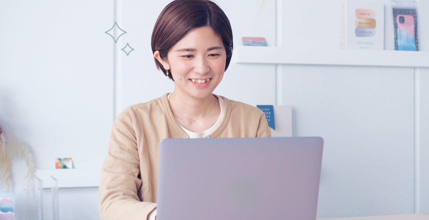 ノートパソコンに向かい微笑む女性
