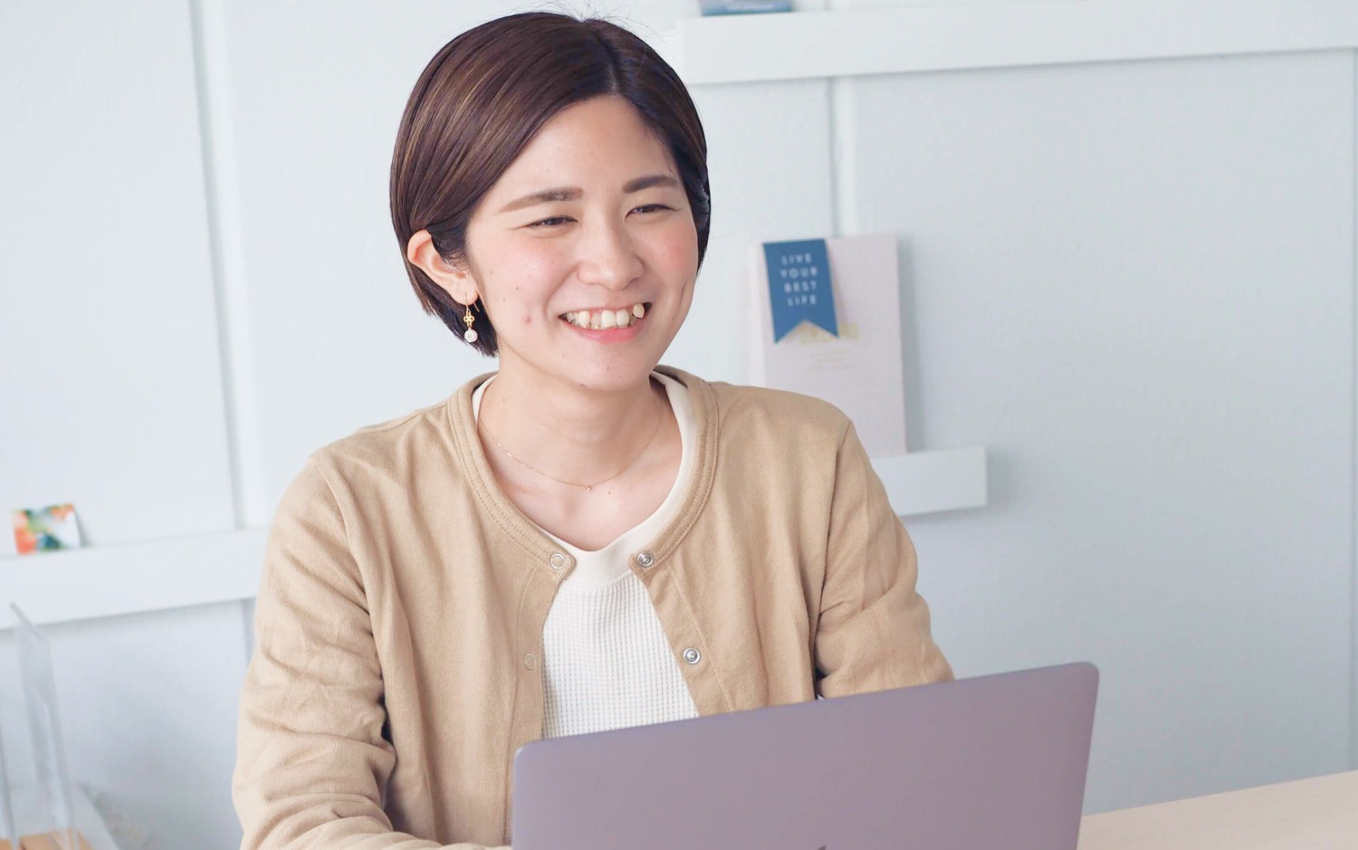 ノートパソコンに向かい微笑む女性