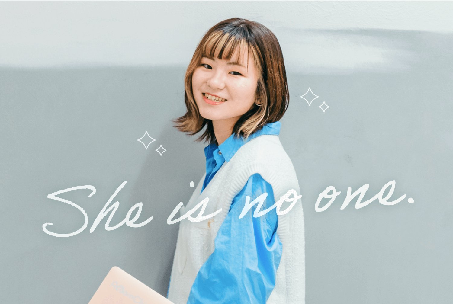 壁にもたれて微笑み振り返る彩華さん(キラキラ装飾・「She is no one.」の筆記体キャプション入り)