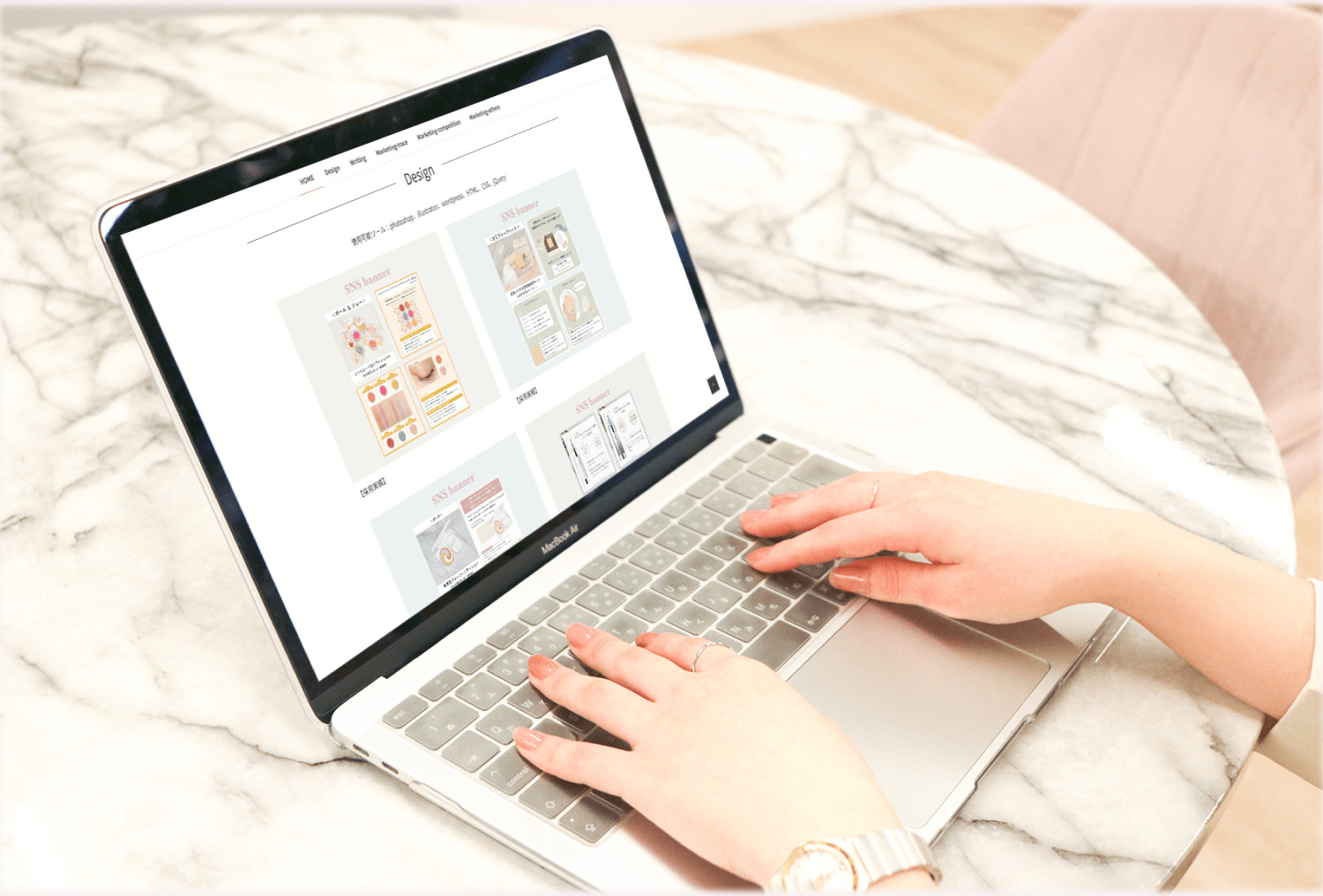 自作ポートフォリオサイト「Design」ページが表示されたノートパソコンを操作するMIYUさんの手元