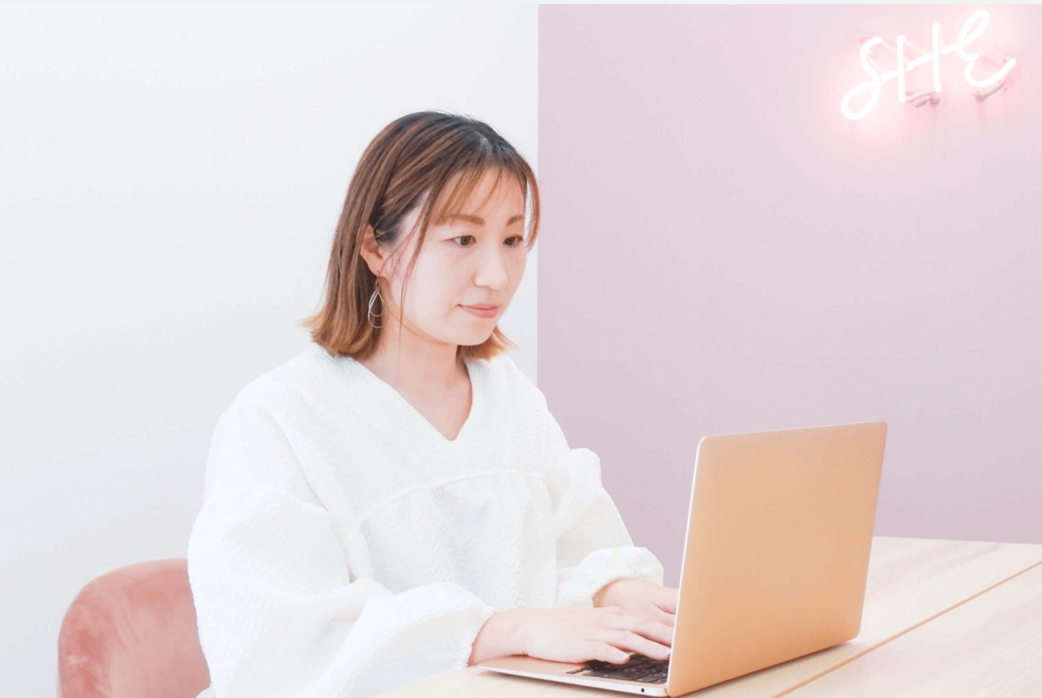 白いブラウス姿のMARIさんがノートPCに向かって作業する写真