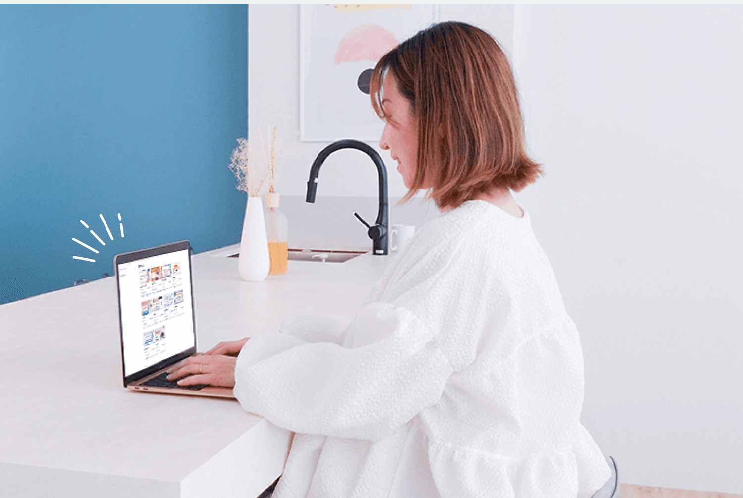 MARIさんがキッチンカウンターでノートPCを使って作業する写真
