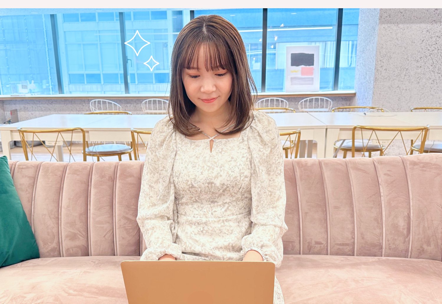 ソファに座りノートPCを操作する本人（キラキラ装飾付き）