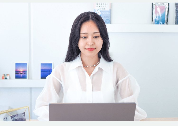 棚の前でノートPCに向かうパウさんの正面写真