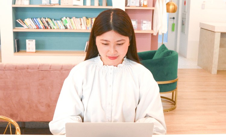 本棚のある落ち着いた空間でノートPCに向かうしおりさん