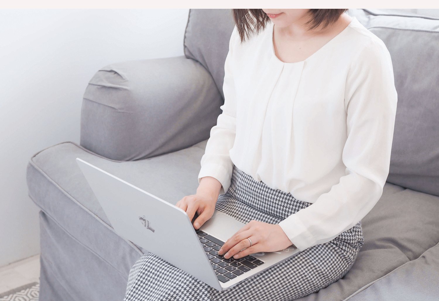 ソファに座り、ノートPCでお仕事をするHANAさん