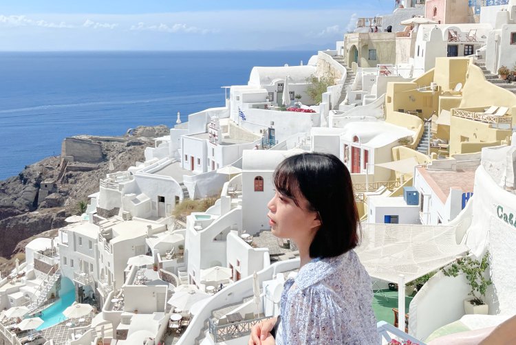 サントリーニ島の白い街並みと海を眺めるいとまりさんの横顔