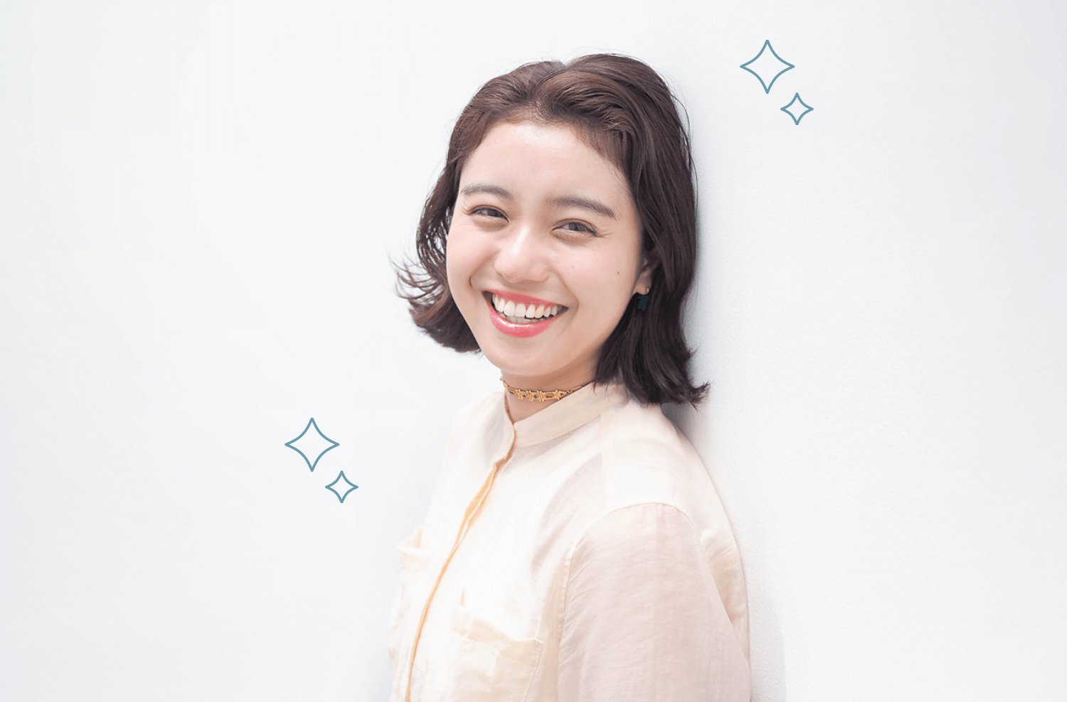 壁にもたれて横を向き微笑む杏珠さん