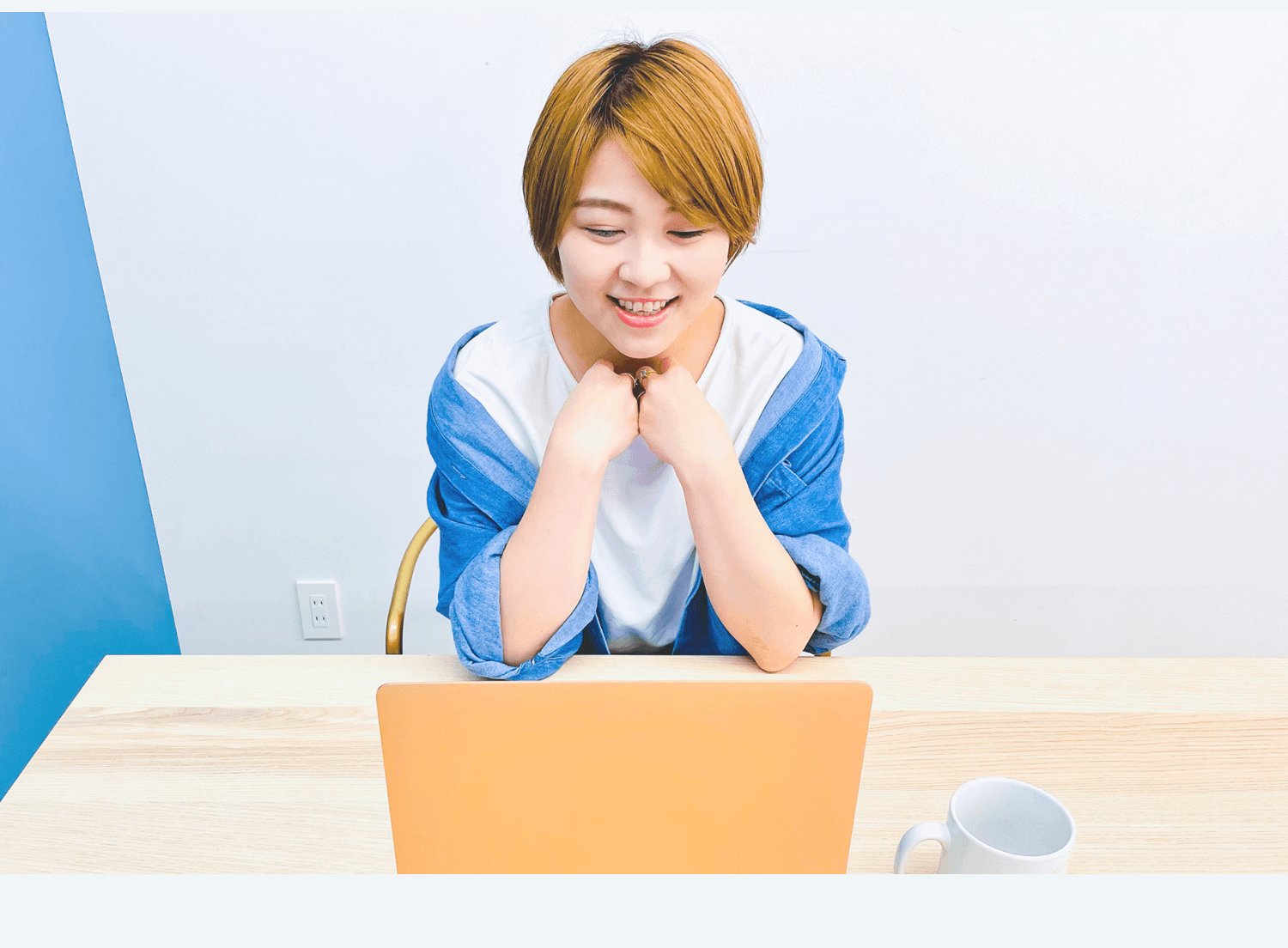 オレンジ色のノートパソコンに向かい微笑むなりーさん