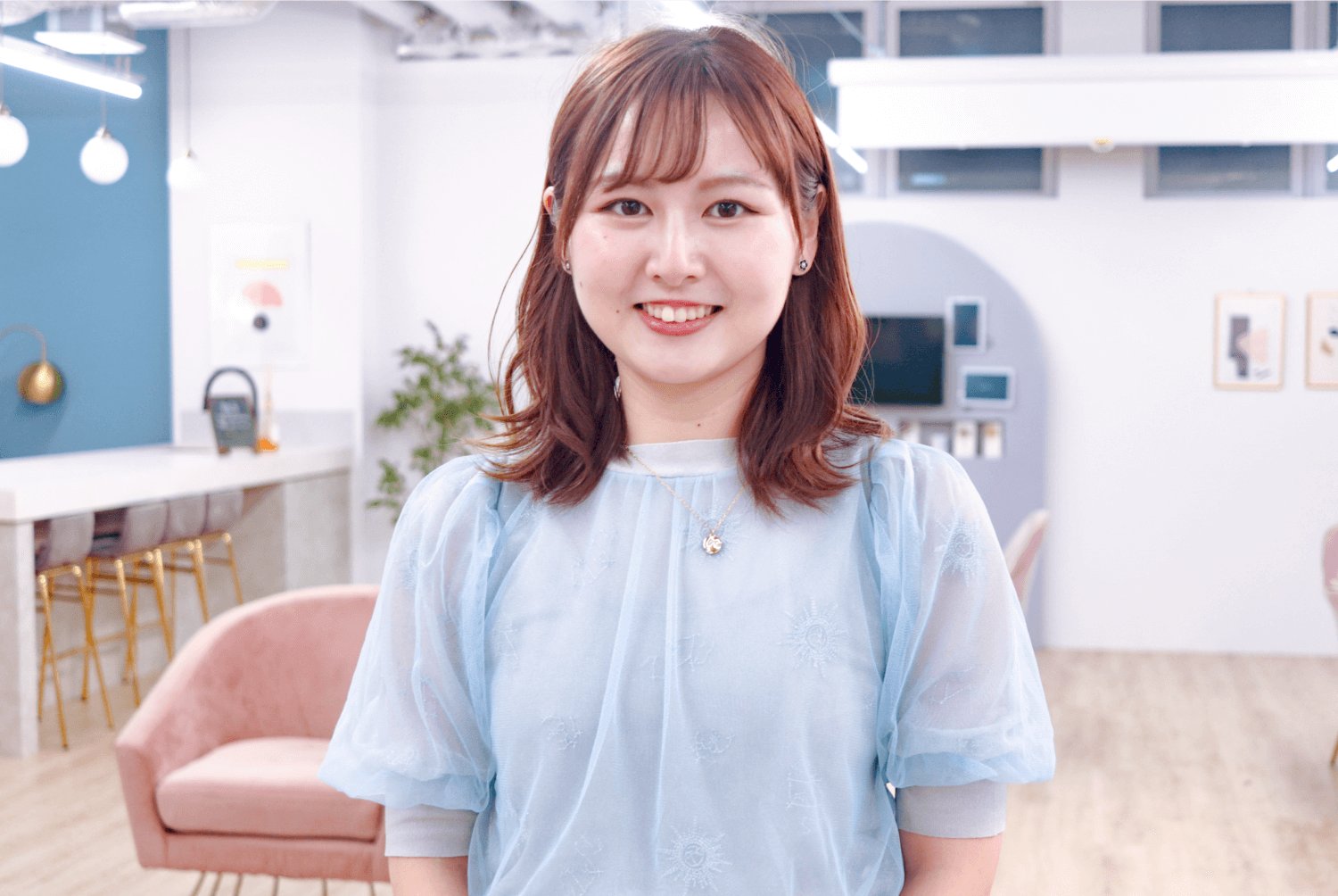 明るいオフィスラウンジでカメラに向かって微笑む琴弓さん