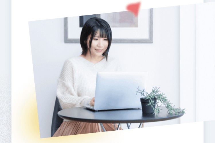 丸テーブルでノートPCに向かって作業するTomoyoさんの写真