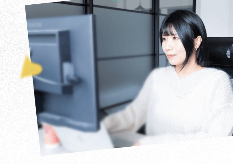 オフィスでモニターに向かって作業するTomoyoさんの写真