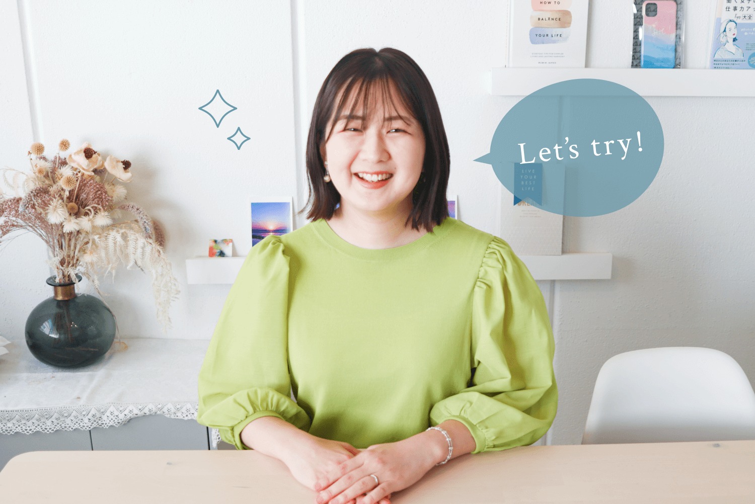 花瓶とドライフラワーが置かれた白い部屋で微笑む美咲さん。隣にティール色の吹き出し風装飾「Let's try!」