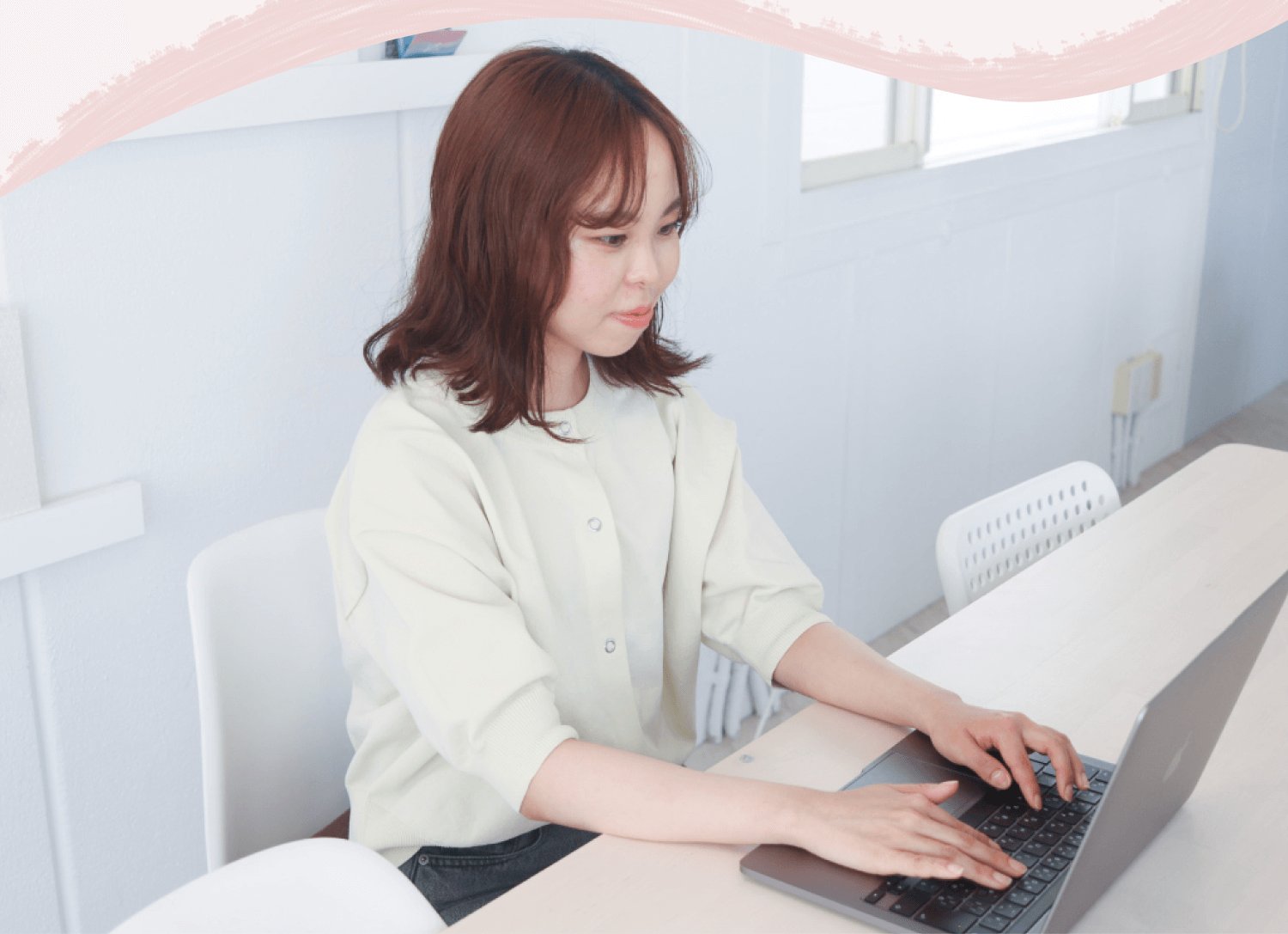 デスクでノートPCに向かって作業する結風さんの横顔・正面寄りポートレート