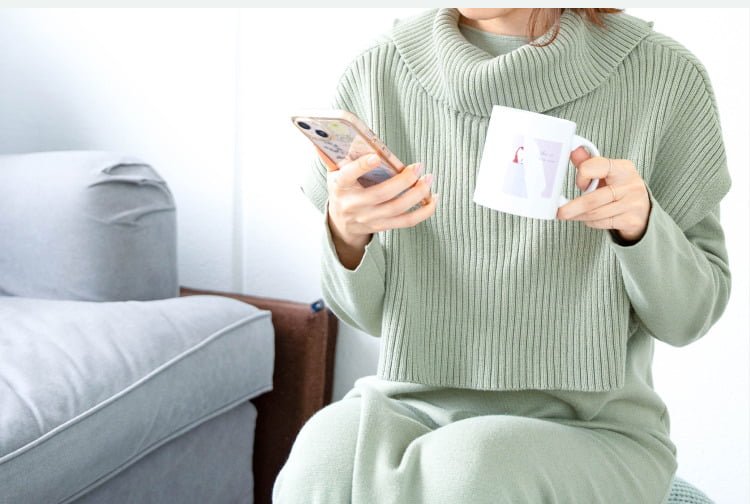 ソファでスマートフォンとマグカップを持つゆきさん
